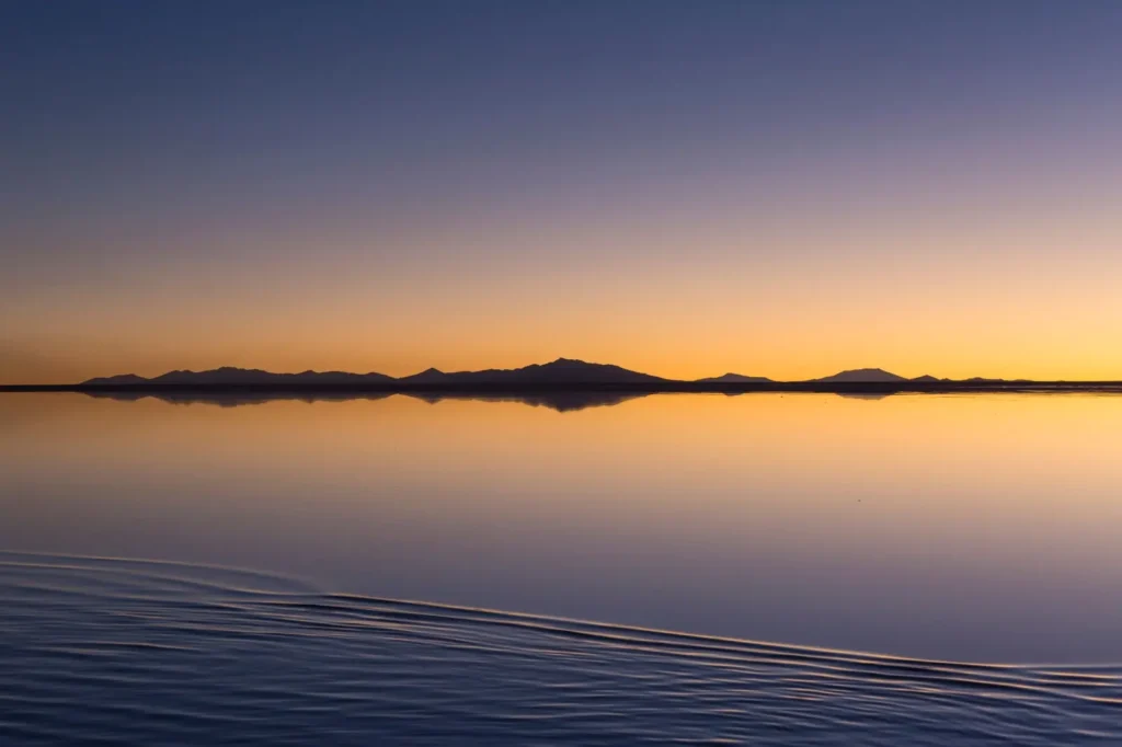 El Salar de Uyuni: el cielo se parte en dos, el espejo de agua duplica el horizonte, y decenas de turistas intentan capturar el momento.